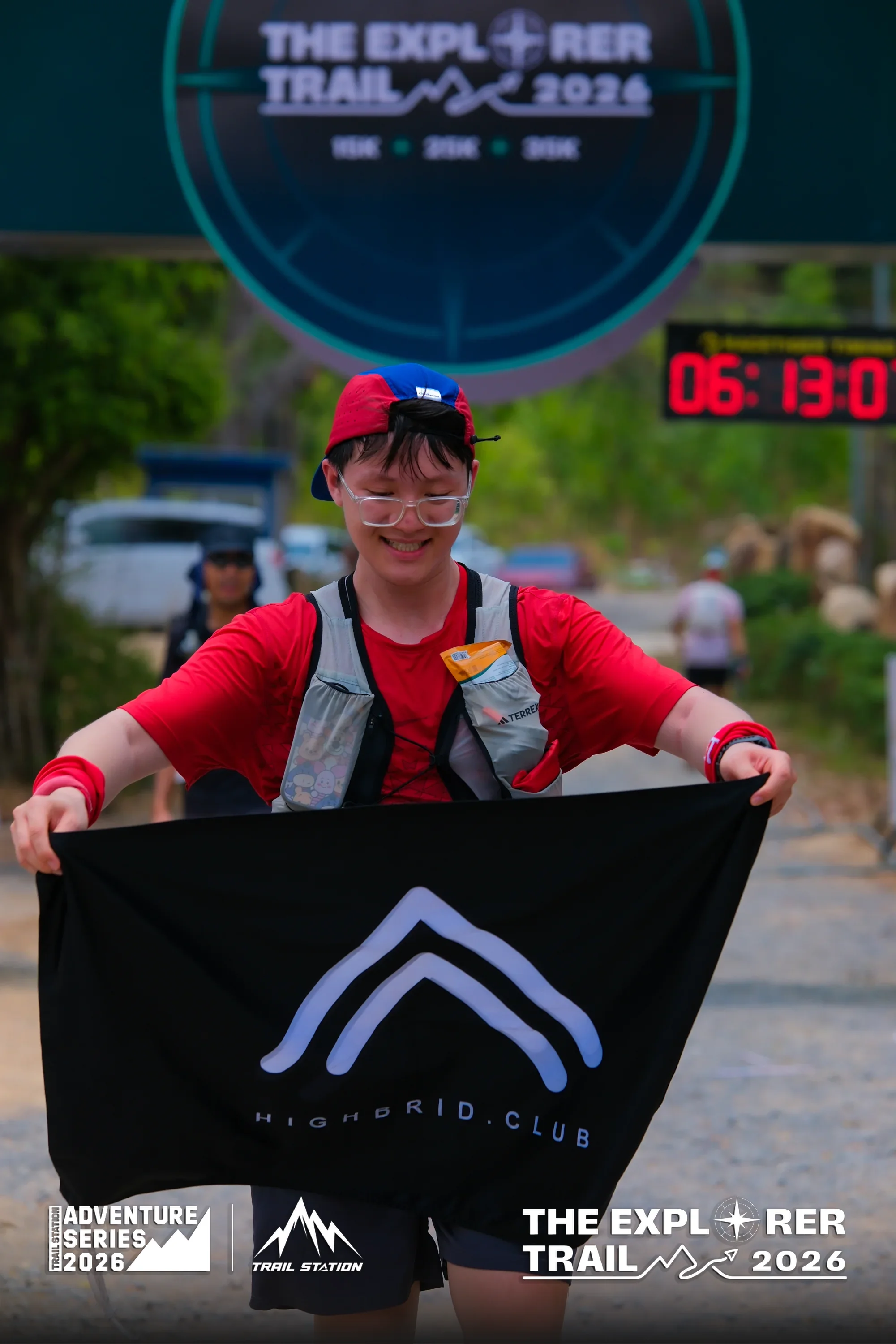 Runner holding Highbrid Club flag at The Explorer Trail finish