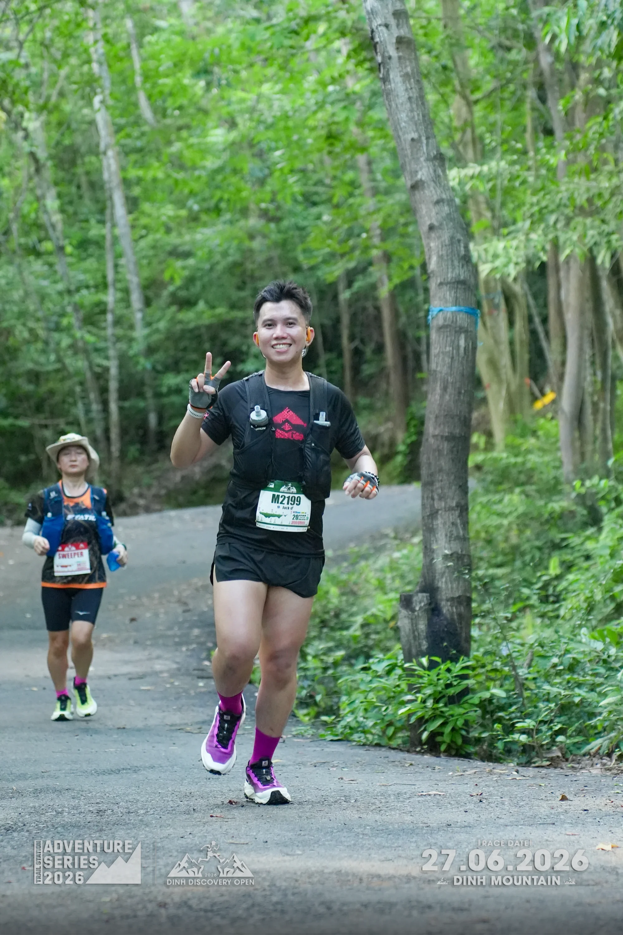 Runner giving peace sign on Dinh Discovery Open trail